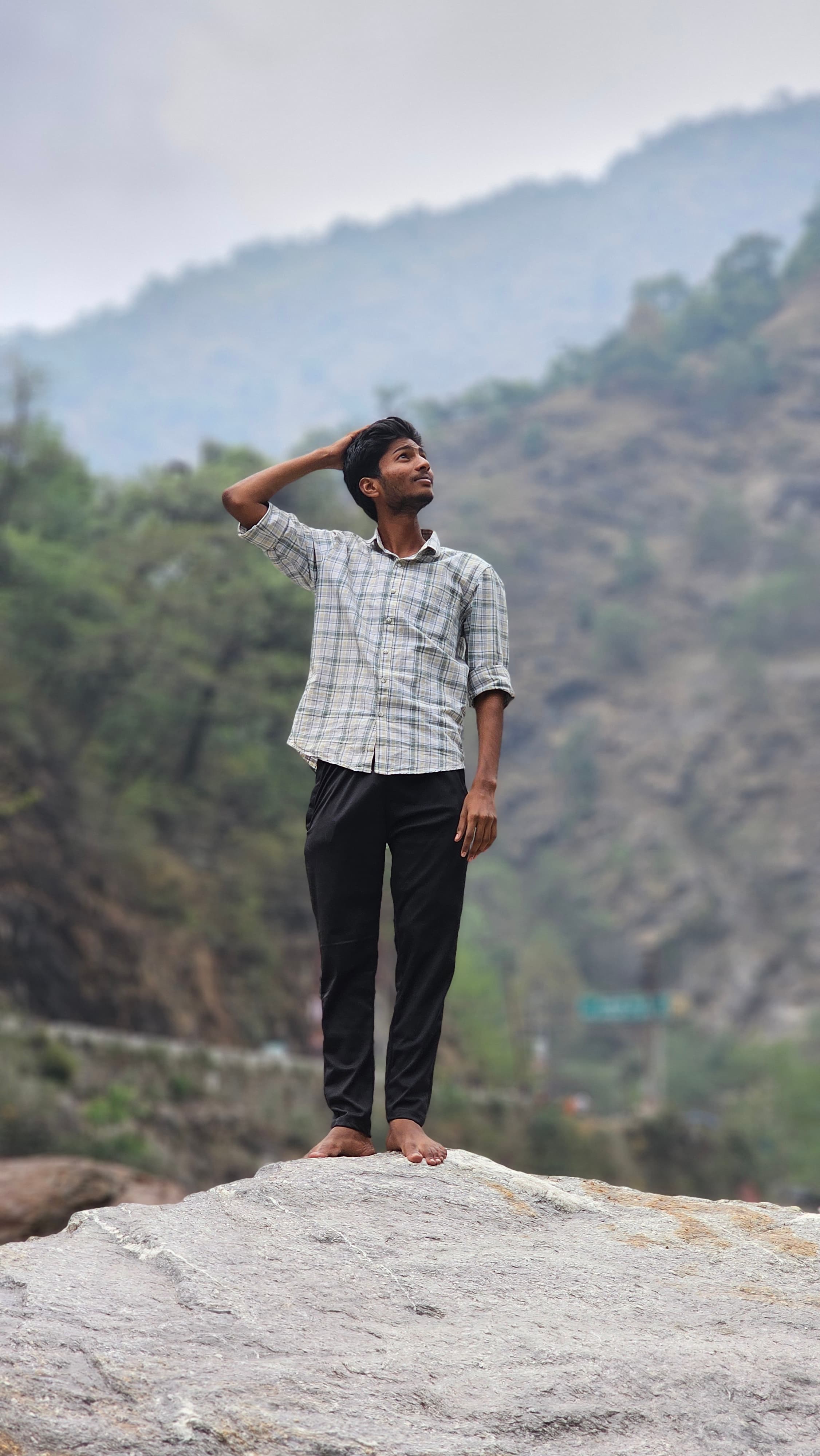 Tarak Ram standing on a mountain overlooking a beautiful landscape